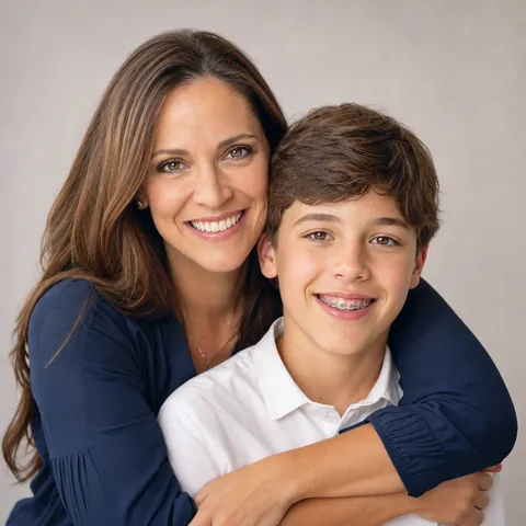 Mother hugging her smiling son who wears braces