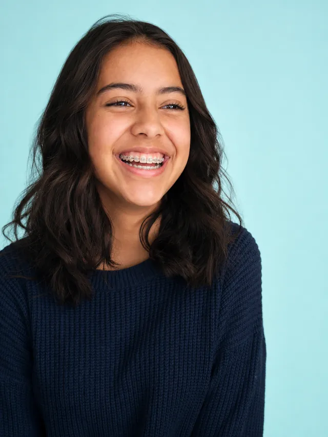 Smiling teenage girl with clear ceramic braces